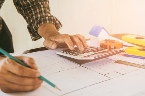 istock Concept architects,engineer holding pen pointing equipment architects On the desk with a blueprint in the office, Vintage, Sunset light.Selective Focus 955791418