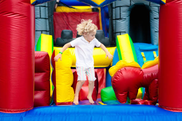 istock Child jumping on playground trampoline. Kids jump. 955794980