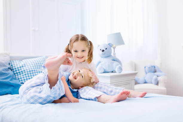 istock Kids playing in white bedroom 955799540