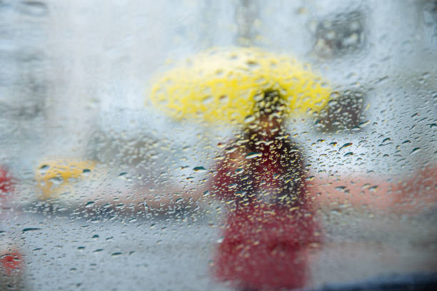 ガラスに濡れた雨粒します。濡れたコップを黄色のシルエットを持つ女性 - umbrella women storm yellow ストックフォトと画像