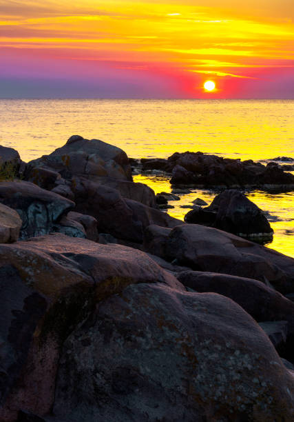 istock reddish sunrise over the sea with rocky shore 955800328