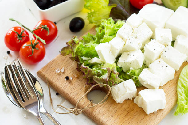 cooking qreek salad with fresh vegetables, feta cheese and black olives on a white wooden table. - 11262 imagens e fotografias de stock