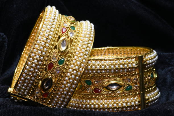 istock Golden bracelet pair on black background 955801440