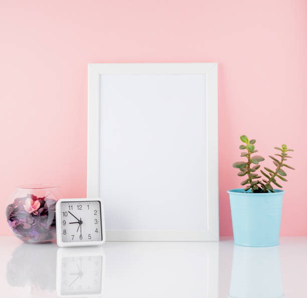 istock Blank white frame and plant cactus, on a white table against the pink wall with copy space. Mockup with copy space. 955804030