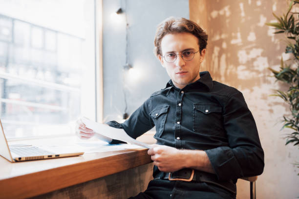istock Relaxed young professional surfing the Internet on his laptop in a cafe 955804604