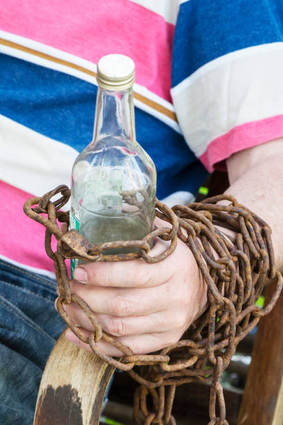 ręcznie przykuty do butelki alkoholu, mężczyzna siedzący na krześle - brandy bottle alcohol studio shot zdjęcia i obrazy z banku zdjęć