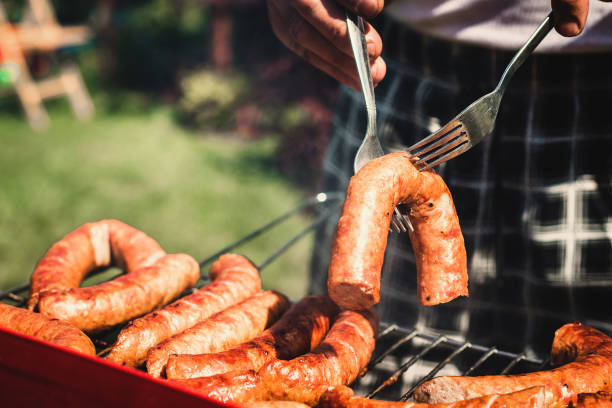 Pulling the sausages on the grill.