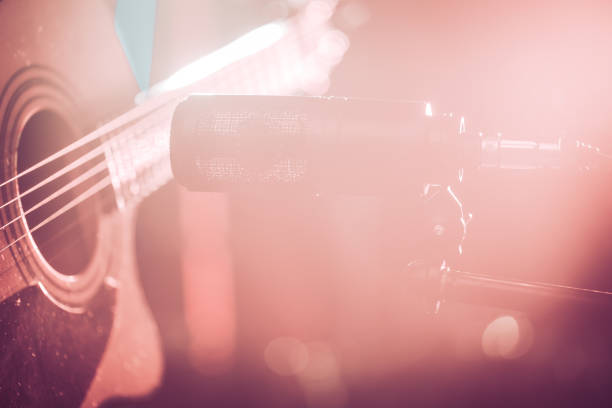 istock The Studio microphone records an acoustic guitar close-up. Beautiful blurred background of colored lanterns. 955820690