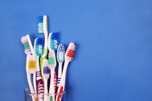 istock Toothbrushes in a glass on blue background 955824072