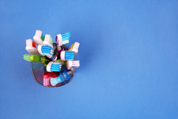 istock Toothbrushes in a glass on blue background 955824076