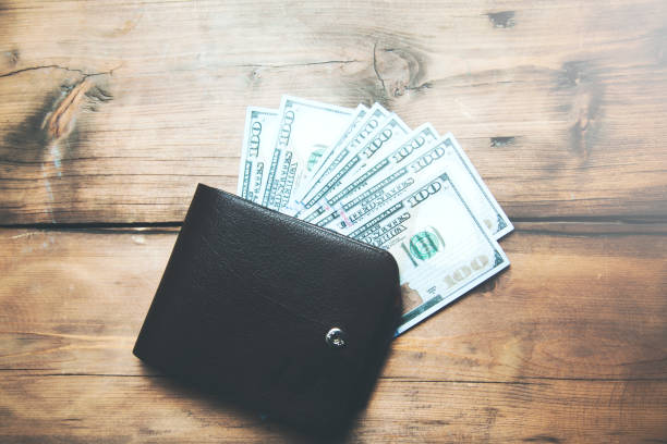 istock Money cash wallet on wooden table with copy space 955827824