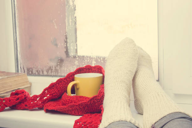 istock woman foot and tea on window 955827904
