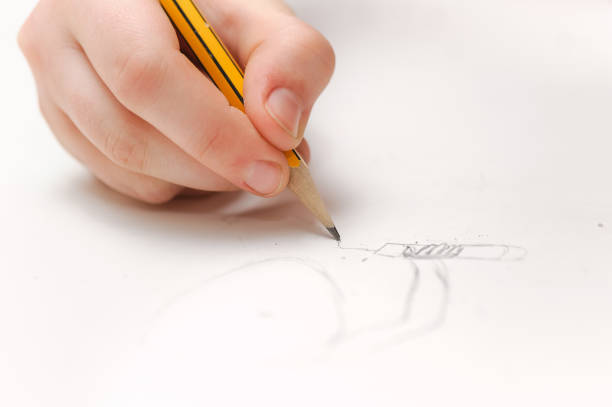 istock hand with pencil on a white paper background 955833554