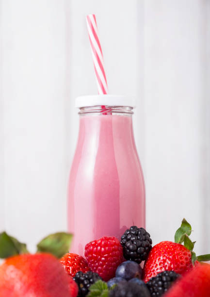 istock Glass bottle with fresh summer berries smoothie 955836614