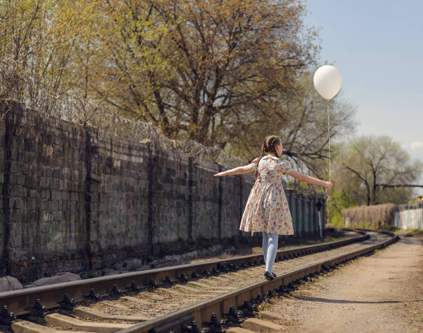 istock girl with pigtail walk on a rails 955836700