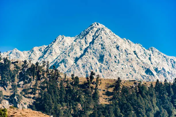 A distant view of Dhauladhar Mountain ranges during a sunny day. Triund, Dharamshala, Himachal Pradesh. India