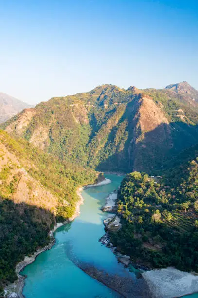 Wonderful green peaks of some mountains with the Ganges river flowing between them in Rishikesh, India