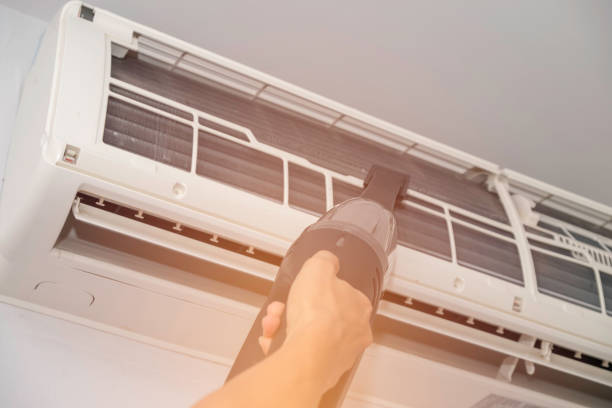 istock Technician check or repair air condition and take off filter to cleaning. Using handheld vacuum cleaner sucking dust on fin of air conditioner 955851548