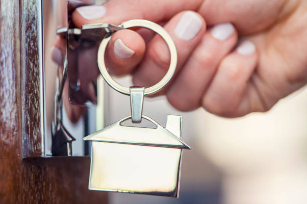 istock Woman using a house key on the front door 955864412