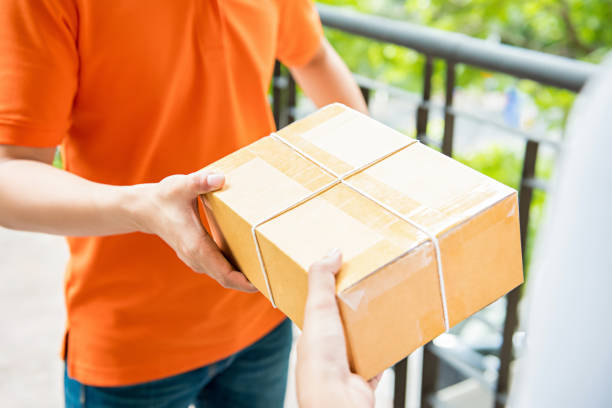 istock Delivery man handing a parcel box over to a customer 955864962