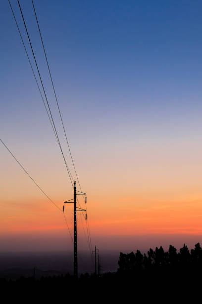 silhouette electricity pole, electricity pylons technology on sunset time background stock photo