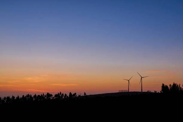 sunset over some wind turbine generator stock photo