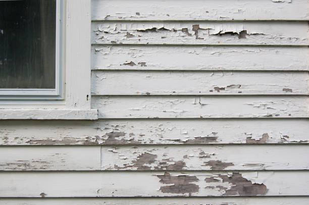 Peeling white paint on siding Peeling white paint on a calpboard hose with part of window peeling off stock pictures, royalty-free photos & images