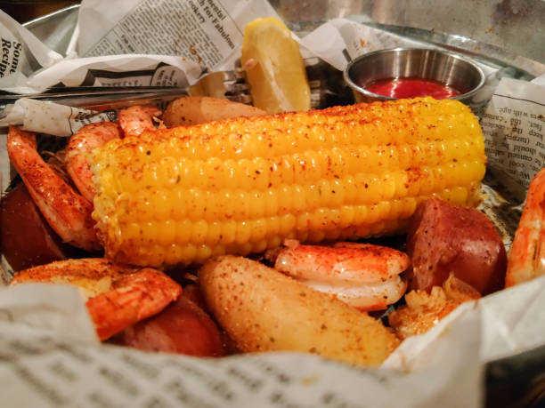 istock shrimp boil with sausage corn potatoes on dinner table 955875710