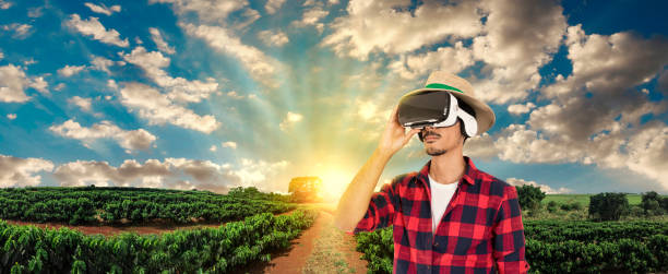 istock Farmer with hat and virtual reality glasses on coffee plantation landscape 955886112