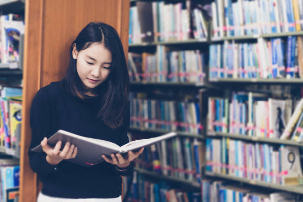 istock Asian students reading books in the library. 955895140