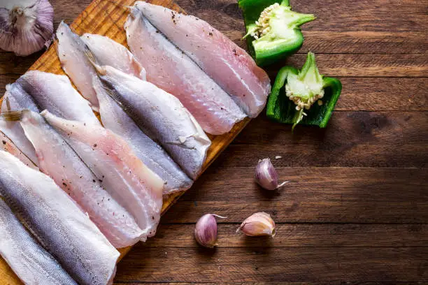 Raw fish on top of a wooden background, table top flat lay