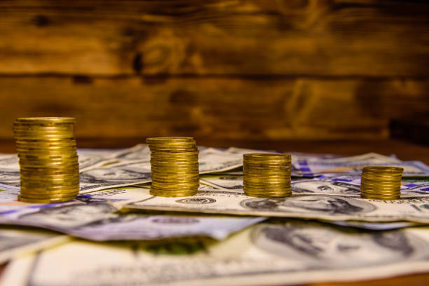 istock Stack of the coins on the one hundred dollar bills 955899834