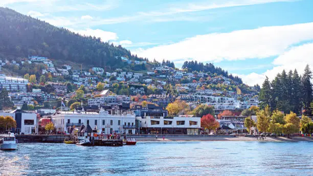 The city of Queenstown and its harbour - colourful buildings and boats across the water towards the marina and shoreline