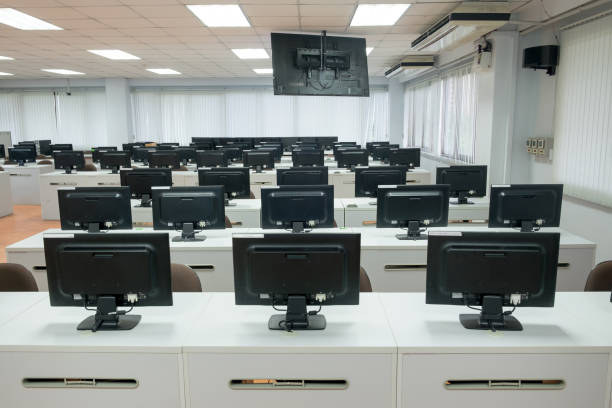 istock Classroom computers. Empty no people with many monitor computer on white desk. 955903288
