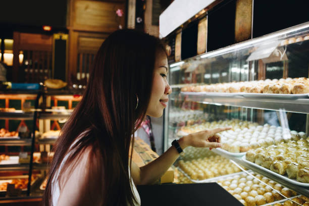 istock Asian girl pointing at Chinese pastries 955909278