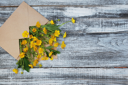Yellow Little Flowers in Envelope Rustic Wooden Background