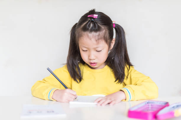 istock Little girl is writing 955913480