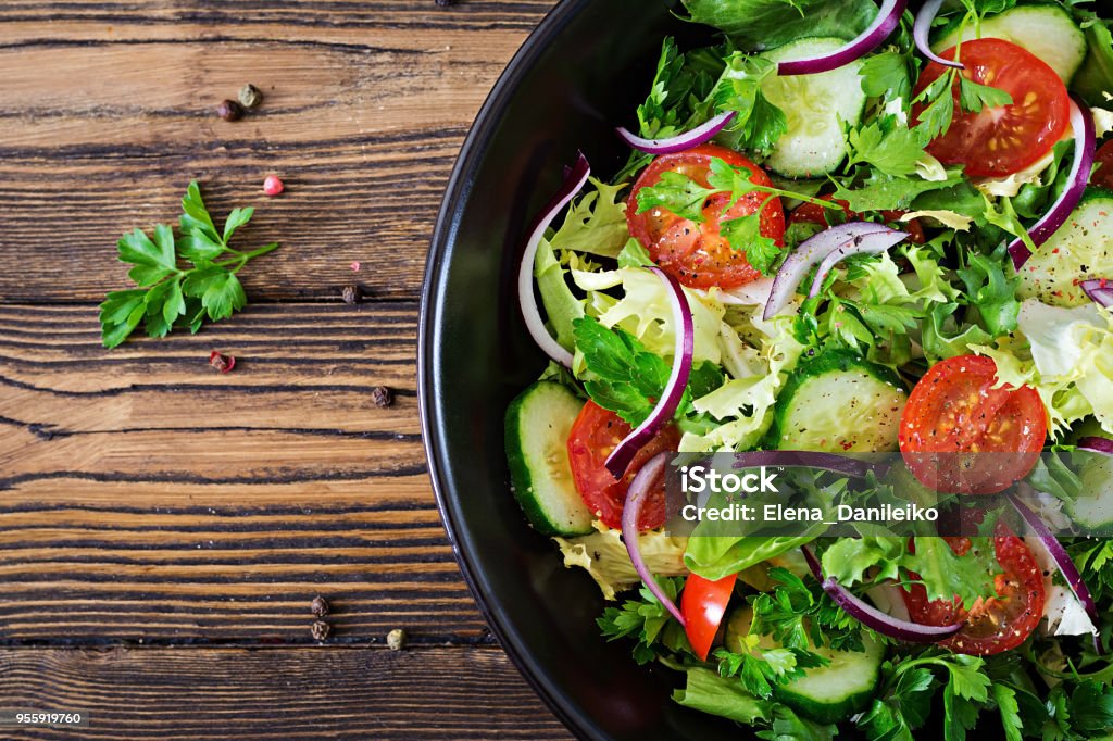 Feuilles de salade de tomates, concombre, laitue et oignons rouges. Menu de vitamine d’été en bonne santé. Nourriture végétale végétalien. Table à dîner végétarien. Vue de dessus. Poser de plat - Photo de Salade composée libre de droits