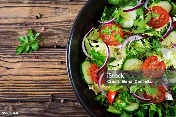 Photo libre de droit de Feuilles De Salade De Tomates Concombre Laitue Et Oignons Rouges Menu De Vitamine Dété En Bonne Santé Nourriture Végétale Végétalien Table À Dîner Végétarien Vue De Dessus Poser De Plat banque d'images et plus d'images libres de droit de Salade composée