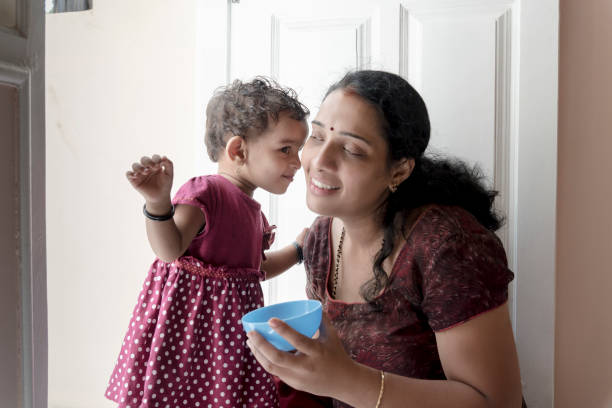mother feeding daughter Indian, mother, food, lunch, feeding, Bangalore, cerial stock pictures, royalty-free photos & images