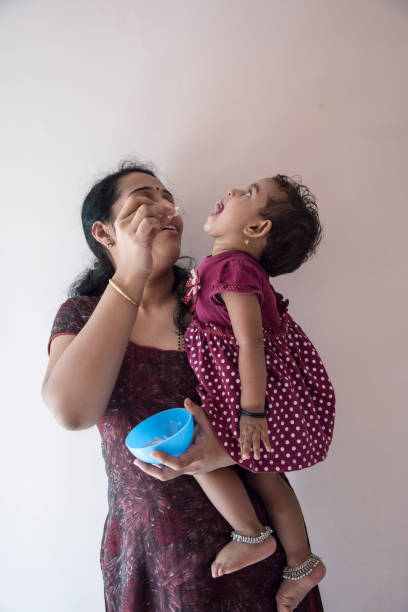 mother feeding daughter Indian, mother, food, lunch, feeding, Bangalore, cerial stock pictures, royalty-free photos & images