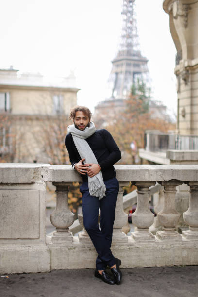 istock Afro american handsome young man standing near concrete railing with Eiffel Tower background in Paris 955921658