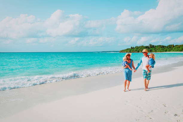 istock happy family with two kids walking on beach 955926334