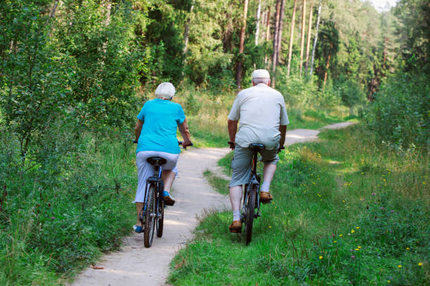istock active senior couple riding bikes in nature 955927076