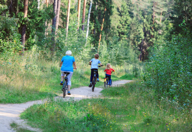 istock active senior grandmother with kids riding bikes in nature 955927190