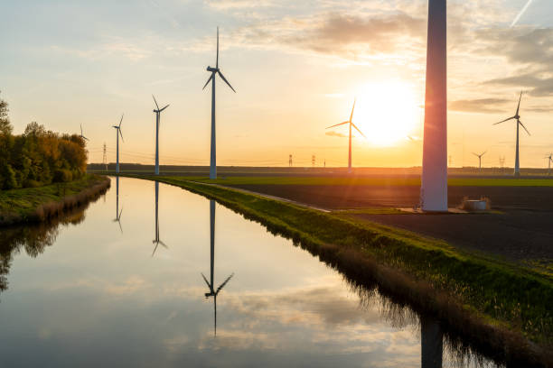 istock Sunset above the windmills on the field and pond 955947232