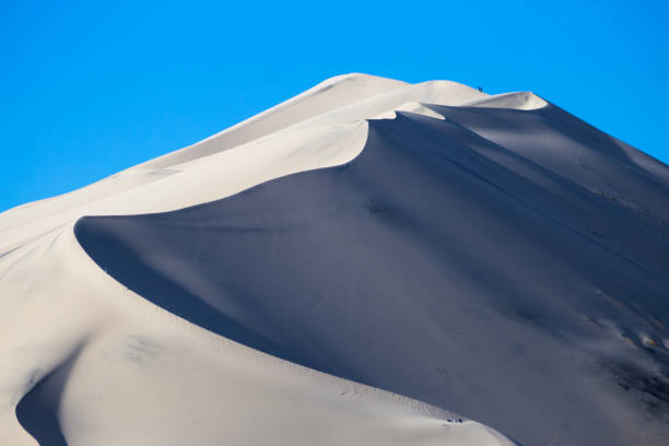 istock Large dunes and small people 955947378