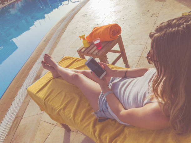 istock Girl using cellphone near the swimming pool. 955950988
