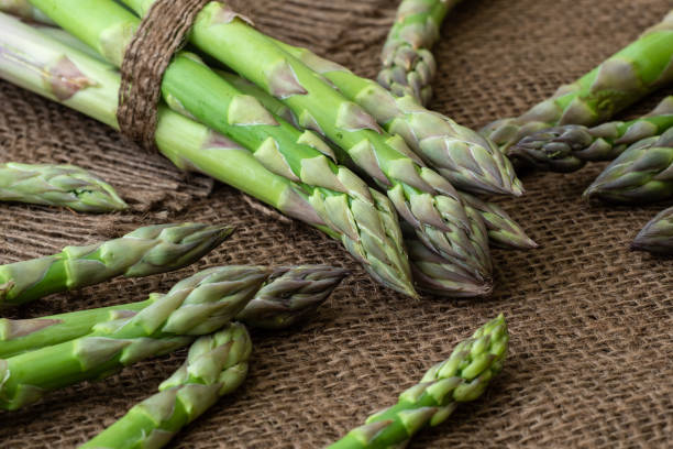 istock Raw garden asparagus stems. Fresh green spring vegetables. (Asparagus officinalis). 955951082