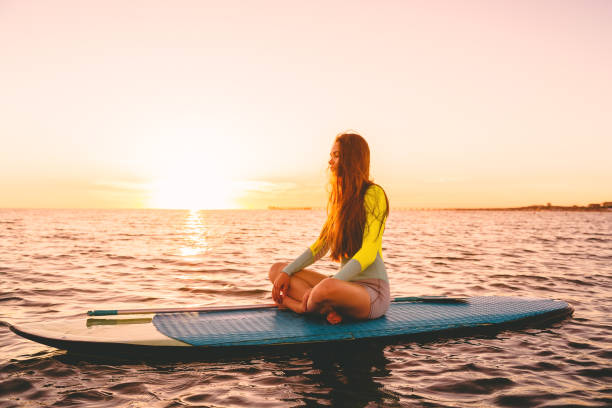 istock Stand up paddle boarding on sea with warm summer sunset colors 955951462
